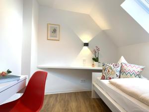 ein Schlafzimmer mit einem Bett und einem roten Stuhl in der Unterkunft Hotel B54 Heidelberg City Center in Heidelberg