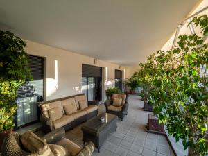 a living room with a couch and chairs and plants at Apto Valdespino Gran Terraza fjHomefj in Jerez de la Frontera