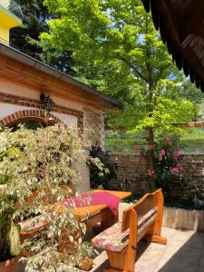 een patio met een tafel en banken in een tuin bij Hotel Jambo in Goudstrand