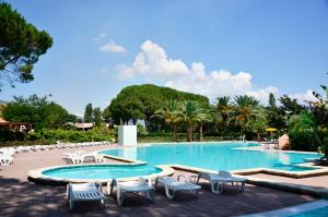 a swimming pool with chaise lounge chairs and a resort at Villaggio Santandrea Resort in SantʼAndrea Apostolo dello Ionio