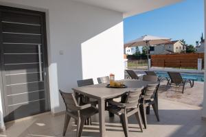 un patio con mesa de comedor y sillas en Coral Bay Villa 10 en Coral Bay