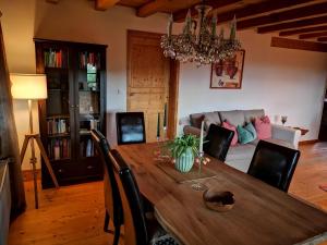 a dining room with a wooden table and a couch at Villa Grenzenlos in Löffingen