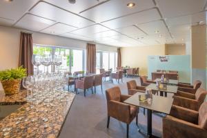 ein Restaurant mit Stühlen, Tischen und Weingläsern in der Unterkunft Hotel Am Kurpark Späth in Bad Windsheim