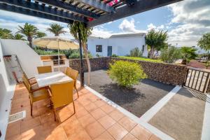 a patio with a table and chairs and an umbrella at Ona Las Casitas in Playa Blanca