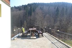 a patio with a table and chairs on a balcony at Vila Pitty in Sinaia