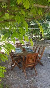 uma mesa de madeira e cadeiras debaixo de uma árvore em Domaine de Bonnet em Castelnau-de-Lévis