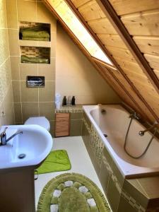 a bathroom with a sink and a tub and a toilet at Domek nad stawem in Sławutowo