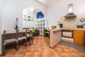- une cuisine et un salon avec une table et un comptoir dans l'établissement Casa das Camélias, à Arco da Calheta