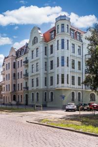 a large building with cars parked in front of it at Apartamenty Katrin Home in Toruń