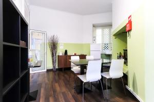 a kitchen and dining room with a table and white chairs at Lisbon Garden Flower in Lisbon