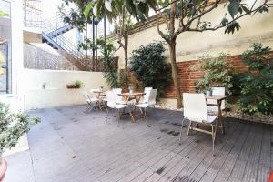 a patio with tables and chairs and a tree at Lisbon Garden Flower in Lisbon