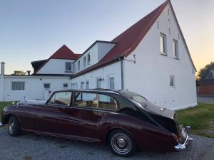 ein altes Auto, das vor einem Gebäude geparkt ist in der Unterkunft Überfahrt vor Sylt in Klanxbüll