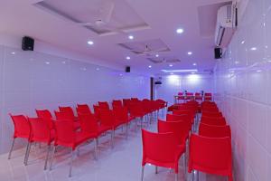 uma sala de conferências com cadeiras vermelhas e uma parede em Laila Palace em Salem