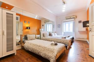 two beds in a room with orange walls at Lisbon Garden Flower in Lisbon