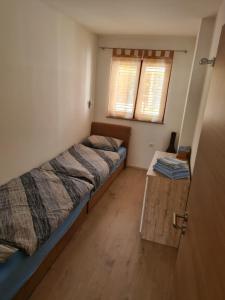niewielka sypialnia z 2 łóżkami i stołem w obiekcie Apartments Dupin w Bašce