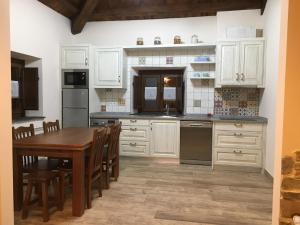 a kitchen with white cabinets and a wooden table at La Casa Vieja de Caneo - APARTAMENTOS RURALES 3 llaves in Luarca