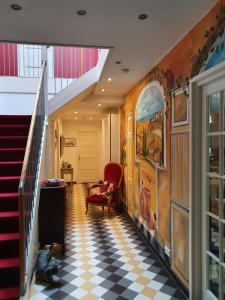 a hallway with a checkered floor and stairs at De Rode Beuk in Wassenaar