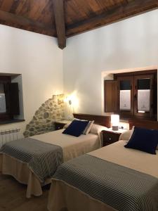 a bedroom with two beds and a stone wall at La Casa Vieja de Caneo - APARTAMENTOS RURALES 3 llaves in Luarca
