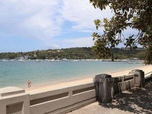 a person standing on a beach near the water at KOZYGURU Chatswood Luxury Studio NCH088-720 in Sydney