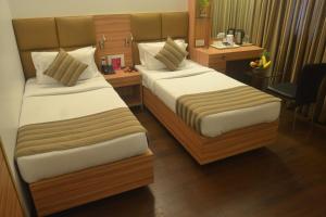 a hotel room with two beds and a desk at Hotel Plaza in Mumbai +68 photos