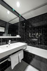 a bathroom with a sink and a bath tub at Expo Hotel in Prague