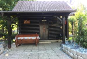une maison en bois avec un banc devant elle dans l'établissement Apartma Tjaša-Terme Čatež, à Čatež ob Savi