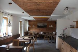 a restaurant with wooden ceilings and tables and chairs at Hofschenke Pfeiftal - Heuduft in San Martino