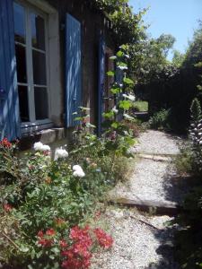 une maison avec une fenêtre et des fleurs devant elle dans l'établissement The Bean Barn, à Arçais