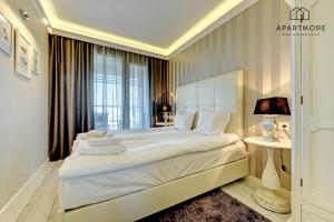 1 dormitorio con 1 cama blanca grande y ventana en City Center - AURA by Apartmore en Gdansk
