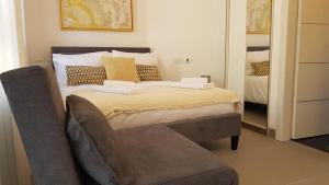 ein Schlafzimmer mit einem Bett mit einem Stuhl daneben in der Unterkunft The Blue House in Jerusalem