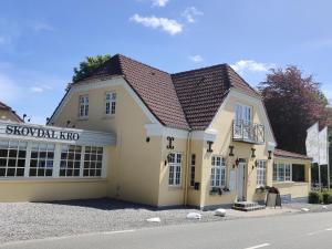 a building with a sign on the side of it at Skovdal Kro in Jelling