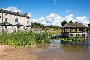 a gazebo in the water next to a building at 12 Borwick Lakes by Waterside Holiday Lodges in Carnforth