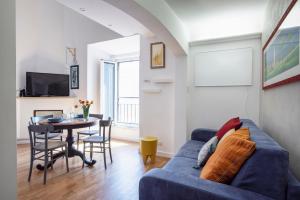 - un salon avec un canapé bleu et une table dans l'établissement Argentina apartment Roof View, à Rome