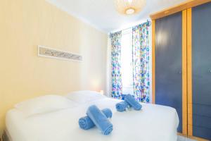 two blue towels on two white beds in a room at Place Amiral Barnaud in Antibes