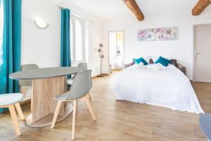 Schlafzimmer mit einem Bett, einem Tisch und Stühlen in der Unterkunft Résidence Le Suquet in Cannes