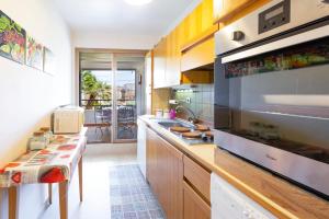 une cuisine avec des armoires en bois et un gros électroménager dans l'établissement Résidence Beauséjour, à Antibes