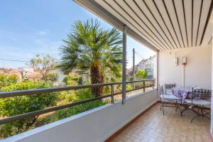 d'un balcon avec un palmier, une table et des chaises. dans l'établissement Résidence Beauséjour, à Antibes