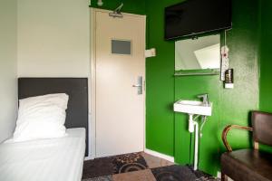 a bedroom with a green wall and a bed and a sink at Princess Hostel Leidse Square Amsterdam in Amsterdam +28 photos