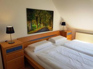 オストゼーバート・ゼリンにあるFewo Granitzblick 6 mit Balkon und Seeblickの壁に絵画が飾られたベッドルーム1室(ベッド2台付)
