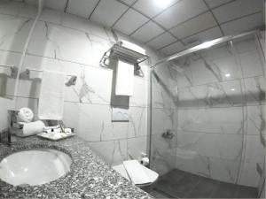 W łazience znajduje się umywalka i przeszklony prysznic. w obiekcie ASİWA HOTEL w mieście Eskişehir