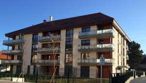 an apartment building with a black fence in front of it at CABANA & Le Manoir - Proche du Lac in Annecy