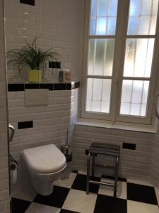 ein Bad mit einem WC, einem Stuhl und einem Fenster in der Unterkunft Le Petit Château des Cedres in Mouchamps