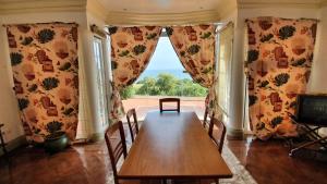 a dining room with a table and a large window at Villa Bouganvilia - Casa da Vigia in Albufeira