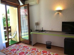 a room with a desk and a sliding glass door at Les Tilleuls Montbeliard Sud Audincourt in Audincourt
