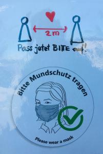 una señal con una persona usando una máscara y las palabras pasan sólo azul y nueve en Pension Weber, en Erfurt