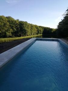 una piscina de agua azul junto a una carretera en Domaine du Ris de Feu, en Chalais