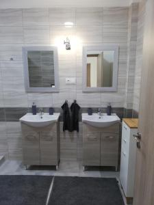 La salle de bains est pourvue de 2 lavabos et d'un miroir. dans l'établissement Bakonybél Nefelejcs Vendégház, à Bakonybél