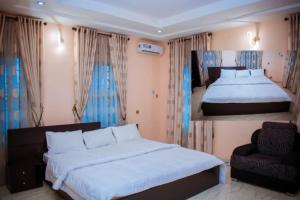 a bedroom with two beds and a chair at Mexiloyd Luxury Rooms & Suites in Port Harcourt
