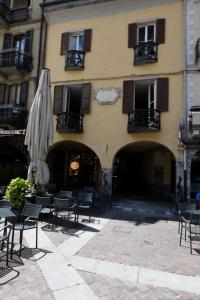 een gebouw met een stel stoelen en een paraplu bij Al Duomo guest house in Como