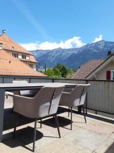 uma mesa e cadeiras numa varanda com montanhas em Hotel Lötschberg em Interlaken